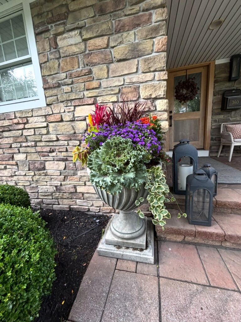 Decorative fall urn planter at a stone front entry